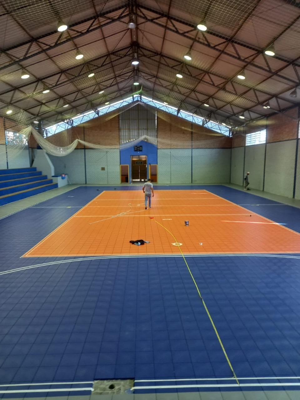 Quadra esportiva modular com piso azul e laranja