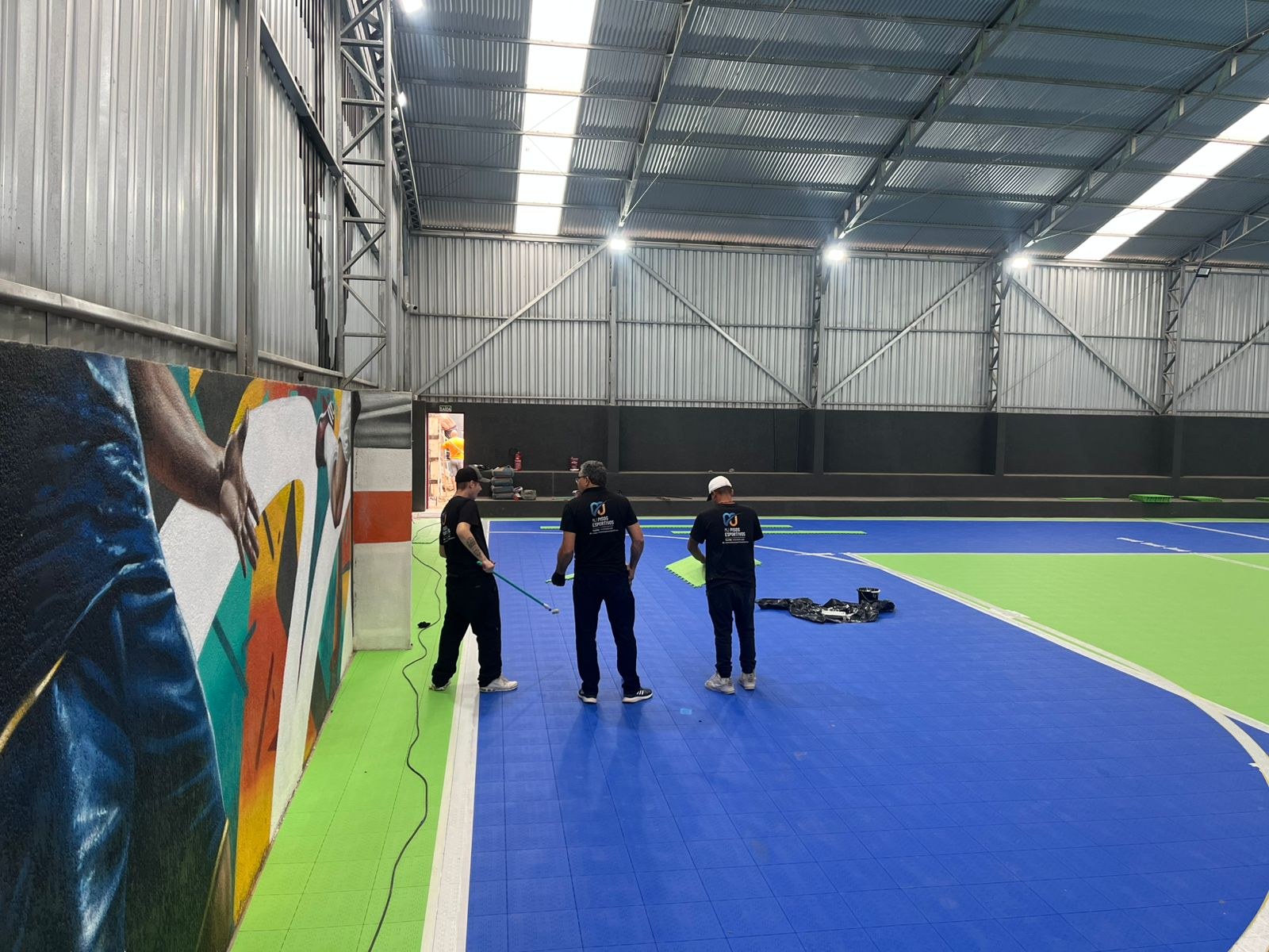 Equipe durante a instalação do piso esportivo